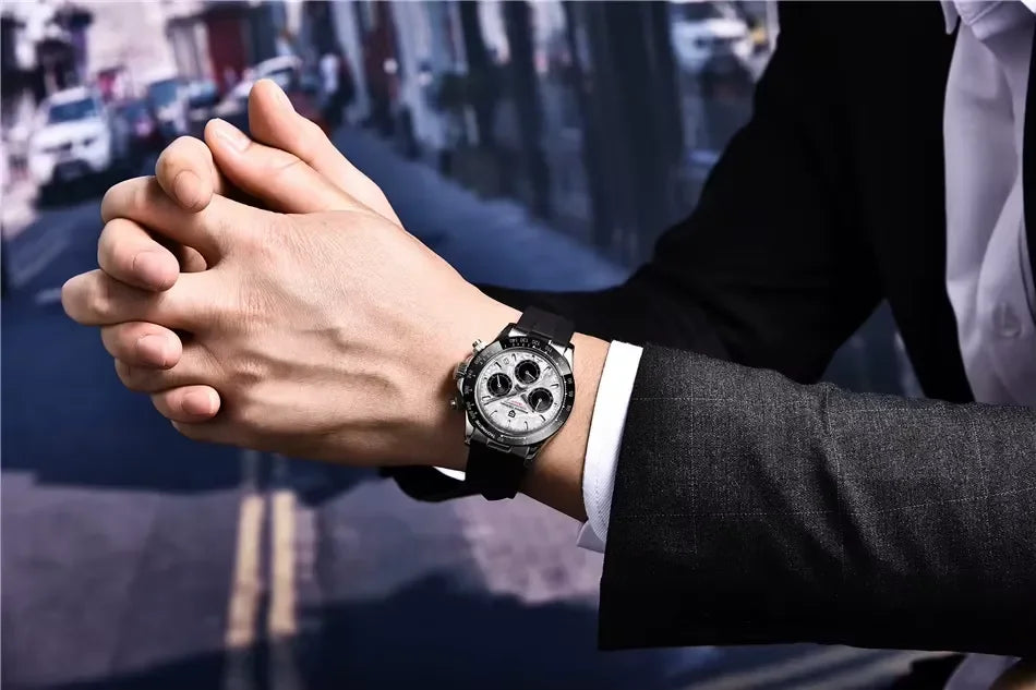 Close-up of a man wearing a silver chronograph watch with black strap on wrist, city street background