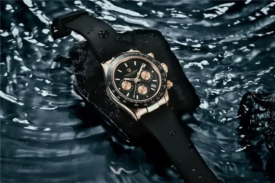 Luxury chronograph wristwatch with black dial, gold subdials, and black strap on wet rock in water