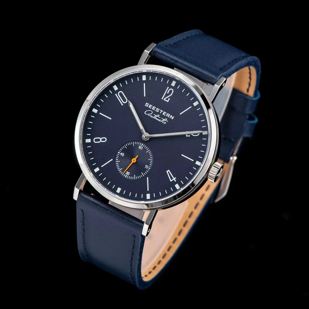 SEESTERN automatic wristwatch with blue dial, silver case, and navy leather strap on black background